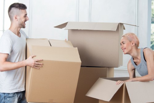 Removalists carrying furniture from a New Malden property